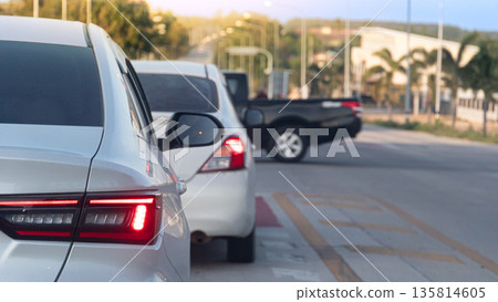 Rear view of white car with LED turn signal indicator. Luxury vehicle exterior part with reflection and blurred road background. Queuing up with a pickup truck crossing the intersection. Rear view of white car with LED turn signal indicator. Luxury vehicle exterior part with reflection and blurred road background. Queuing up with a pickup truck crossing the intersection. 135814605