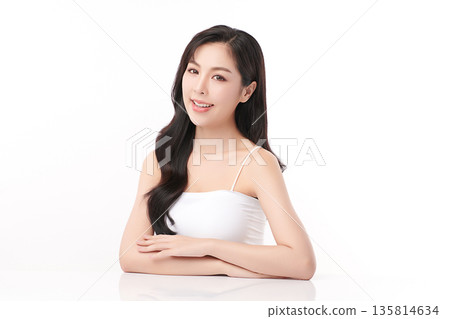 A beautiful young Asian woman with clean, fresh skin against a white background. Skincare, facial treatment, cosmetology, beauty, and spa. An elegant portrait of an Asian woman. 135814634