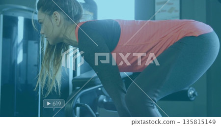 Performing bent-over rowing athlete at gym with machine frame and weight stack overlay showing 619 Performing bent-over rowing athlete at gym with machine frame and weight stack overlay showing 619 135815149