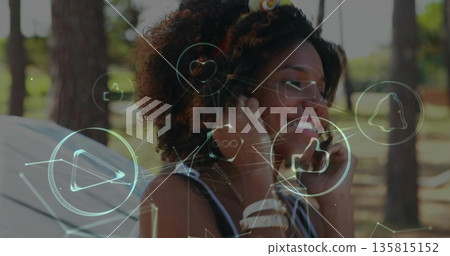 Smiling woman wearing headband standing in wooded clearing, with tent headphones holographic icons 135815152