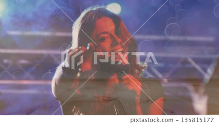 Singing singer holding handheld mic reaching toward audience on music stage with truss lights, haze Singing singer holding handheld mic reaching toward audience on music stage with truss lights, haze 135815177