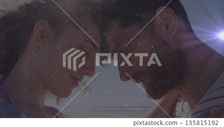 Touching foreheads couple wearing swimwear sharing moment at shoreline, with sunlit star overlay Touching foreheads couple wearing swimwear sharing moment at shoreline, with sunlit star overlay 135815192