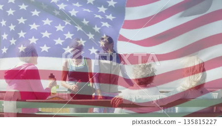 Gathering women on waterfront bench holding water bottle and fitness bag, American flag overlay 135815227