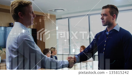 Shaking hands two male colleagues sealing agreement in conference room, with finance chart overlays 135815242