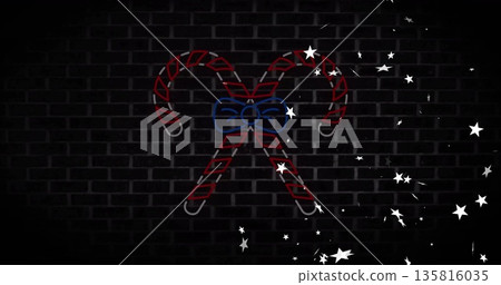 Neon candy canes with bow and stars image over dark brick wall 135816035