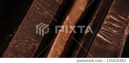 Dark chocolate macro texture with layered shards and rich cocoa surface Dark chocolate macro texture with layered shards and rich cocoa surface 135816362