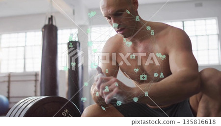 Leaning shirtless man in gray shorts on gym bench, with loaded barbell punching bag fitness icons 135816618