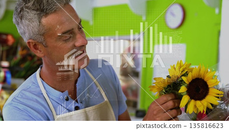 Selecting male florist arranging sunflower bouquet at flower shop counter, with data chart overlays Selecting male florist arranging sunflower bouquet at flower shop counter, with data chart overlays 135816623