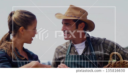 Talking woman and man discussing work in studio, with wicker basket, straw hat and striped aprons Talking woman and man discussing work in studio, with wicker basket, straw hat and striped aprons 135816630