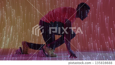 Crouching athlete wearing beige shoes preparing sprint start in studio, with fiber-optic lights Crouching athlete wearing beige shoes preparing sprint start in studio, with fiber-optic lights 135816688