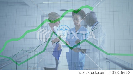 Medical staff consulting over green graph overlay in hospital hall, with clipboard, stethoscope 135816690