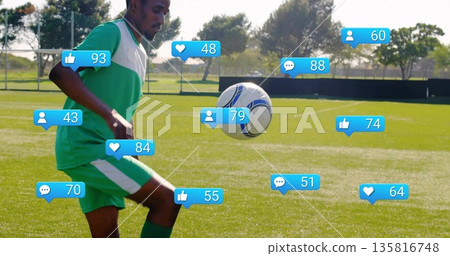 Juggling soccer player controlling white-blue ball thigh-high on turf, with media icons, copy space 135816748