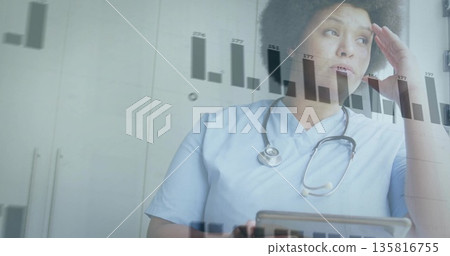 Holding tablet nurse analyzing data at nurse station, stethoscope and bar chart overlay, copy space 135816755