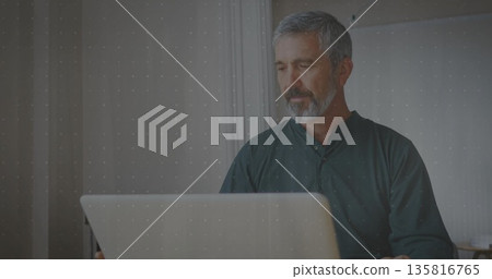 Typing mature adult male focusing on screen at home office, with silver laptop, copy space Typing mature adult male focusing on screen at home office, with silver laptop, copy space 135816765