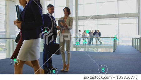 Reviewing tablet, female professional discussing digital icons in corporate atrium with briefcase Reviewing tablet, female professional discussing digital icons in corporate atrium with briefcase 135816773