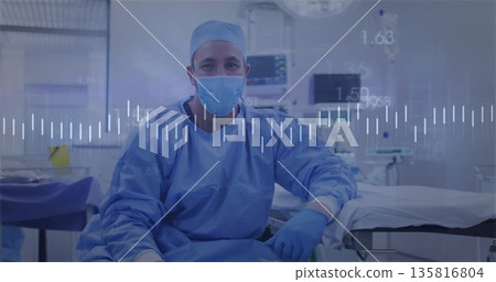Sitting male surgeon preparing for procedure at sterile surgical suite, with vital signs monitors Sitting male surgeon preparing for procedure at sterile surgical suite, with vital signs monitors 135816804