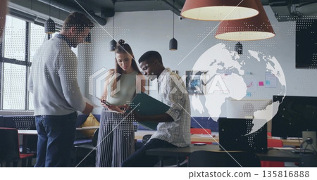 Collaborating colleagues reviewing documents around high table in open office, with green folder 135816888