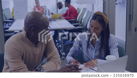 Reviewing documents senior man and Korean woman writing at conference table, with laptop and pen Reviewing documents senior man and Korean woman writing at conference table, with laptop and pen 135816970