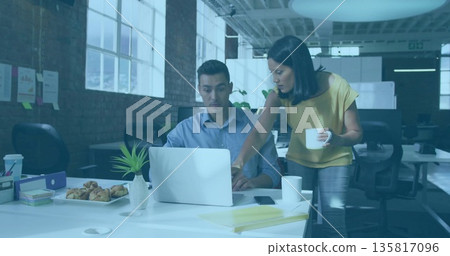 Collaborating coworkers brainstorming at desk in office, with laptop and pastries Collaborating coworkers brainstorming at desk in office, with laptop and pastries 135817096