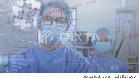 Monitoring surgeons in scrubs viewing overlaid data in operating room, with monitors, IV stand 135817109