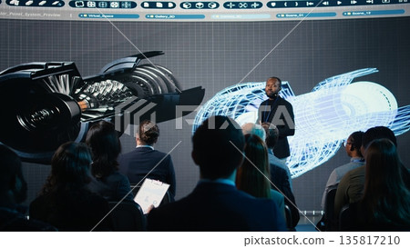 African american speaker does futuristic industrial presentation with a turbine, panel discussion about heavy industry manufacturing. Professional speaker talks to investors attendees. African american speaker does futuristic industrial presentation with a turbine, panel discussion about heavy industry manufacturing. Professional speaker talks to investors attendees. 135817210