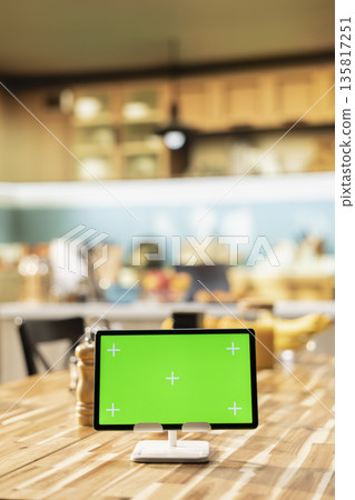 Isolated chroma key on tablet in rustic wooden stylish kitchen space decorated with modern appliances and kitchenware, cozy atmosphere with interior design at the dining table. Isolated chroma key on tablet in rustic wooden stylish kitchen space decorated with modern appliances and kitchenware, cozy atmosphere with interior design at the dining table. 135817251
