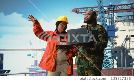 Military personnel on offshore rig for counter terrorism purposes monitoring operations with laptop. Soldier provides protection to drilling barge, preparing security report on notebook, Military personnel on offshore rig for counter terrorism purposes monitoring operations with laptop. Soldier provides protection to drilling barge, preparing security report on notebook, 135817356