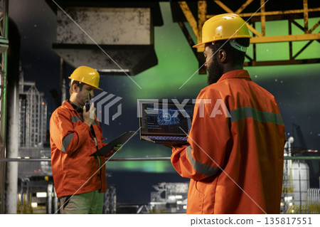 Engineer reviews artificial intelligence systems for offshore oil platform operations, managing fuel extraction through neural networks and deep learning simulation. Fuel production. 135817551