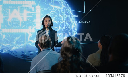 Asian public speaker makes artificial intelligence sales pitch with AI automation and big data analysis. Business forum presentation attracts investors, experts and diverse audience members. 135817578