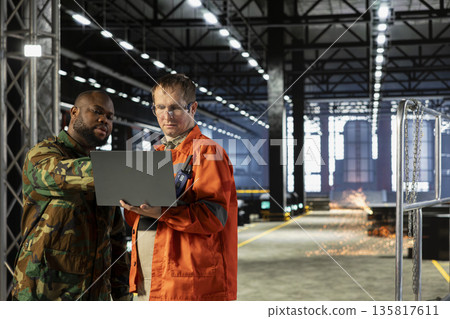 Diverse military officer and staff managing production adapted for armament manufacturing, industrial mobilization supports the wartime economy through precision and national resilience. War effort. 135817611