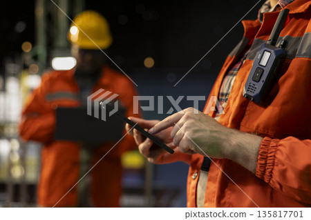 Close up of offshore platform specialist using tablet to analyze extraction efficiency during 24 hour operation. Drilling rig staff members checking vessel management systems with device late at night Close up of offshore platform specialist using tablet to analyze extraction efficiency during 24 hour operation. Drilling rig staff members checking vessel management systems with device late at night 135817701