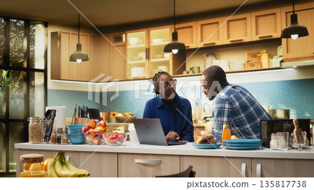 African american people preparing delicious breakfast and drinking coffee, following online recipe on laptop. Getting ready to eat toast slices and croissants, healthy food. African american people preparing delicious breakfast and drinking coffee, following online recipe on laptop. Getting ready to eat toast slices and croissants, healthy food. 135817738