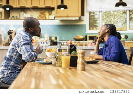 Black boyfriend trying to catch attention of detached distracted girlfriend, zoned out woman being absent and distant from her partner in the morning. Disconnected preoccupied girl. 135817821