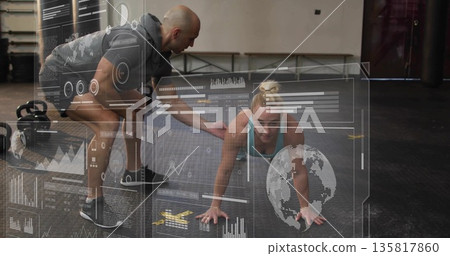 Male trainer guiding female client holding plank in CrossFit gym, with kettlebell and data overlay 135817860