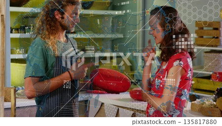 Presenting vendor holding large red cheese wheel at specialty cheese shop counter, wooden shelves Presenting vendor holding large red cheese wheel at specialty cheese shop counter, wooden shelves 135817880