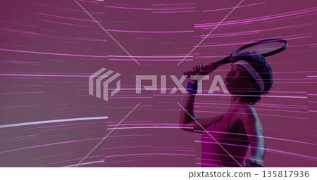 Holding racket overhead, athlete in pink top, white headband, blue wristband in studio, copy space Holding racket overhead, athlete in pink top, white headband, blue wristband in studio, copy space 135817936