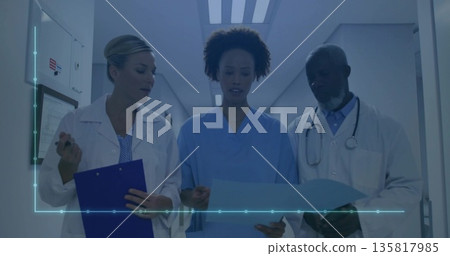 Reviewing patient records team discussing in hospital corridor, with clipboard file and stethoscope 135817985