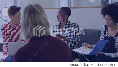 Discussing project four colleagues sitting around coffee table in modern lounge, with laptop charts Discussing project four colleagues sitting around coffee table in modern lounge, with laptop charts 135818163