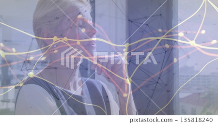 Gazing senior executive resting chin on hand by office window, with network visualization overlay 135818240