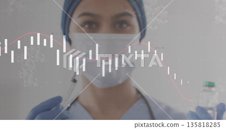 Female medical worker wearing scrubs and stethoscope holding syringe and vial in lab, chart overlay 135818285