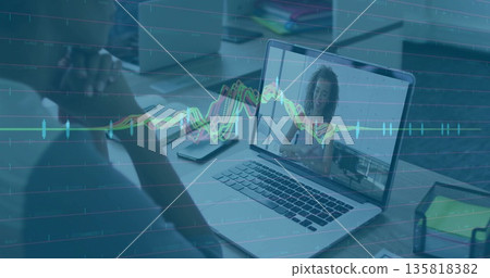 Sitting man facing laptop showing colleague chatting at office workspace with line graph overlay Sitting man facing laptop showing colleague chatting at office workspace with line graph overlay 135818382