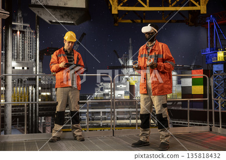 Black engineer with VR glasses on offshore oil platform uses virtual reality tech to simulate drilling operations and monitor machinery, ensuring safety protocols in petroleum extraction. Black engineer with VR glasses on offshore oil platform uses virtual reality tech to simulate drilling operations and monitor machinery, ensuring safety protocols in petroleum extraction. 135818432