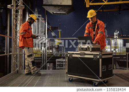 Environmental engineer on offshore platform conducting oil rig inspections, monitoring petroleum extraction to ensure efficient drilling operations within the marine oil industry activity. Environmental engineer on offshore platform conducting oil rig inspections, monitoring petroleum extraction to ensure efficient drilling operations within the marine oil industry activity. 135818434
