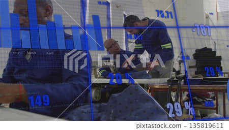 Collaborating three technicians in navy coveralls examining machine part at workshop, data overlay 135819611