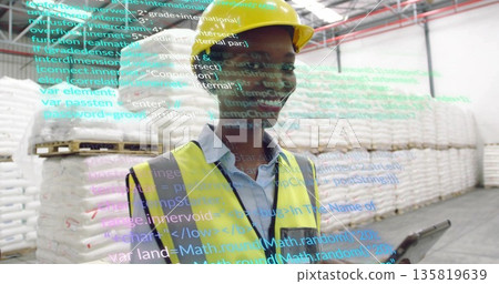 Warehouse inspector wearing safety vest scanning pallets with AR code overlay in aisle, with tablet Warehouse inspector wearing safety vest scanning pallets with AR code overlay in aisle, with tablet 135819639