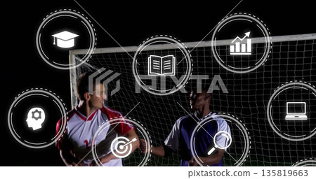 Shaking hands two soccer players in front of goal net under lights, with learning analytics icons 135819663