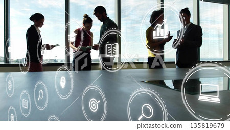 Suited professionals collaborating at conference table with documents, mobile devices and icons 135819679