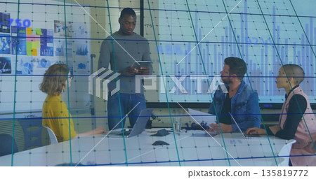 Leading presenter holding tablet guiding colleagues in meeting room, with projection charts Leading presenter holding tablet guiding colleagues in meeting room, with projection charts 135819772