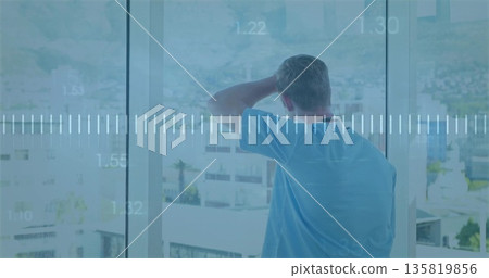 Gazing male resting hand on head in high-rise room before glass window, data waveform overlay 135819856