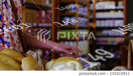 Pointing floral-dress shopper toward bread in wicker baskets on bakery display with grocery shelves Pointing floral-dress shopper toward bread in wicker baskets on bakery display with grocery shelves 135819911